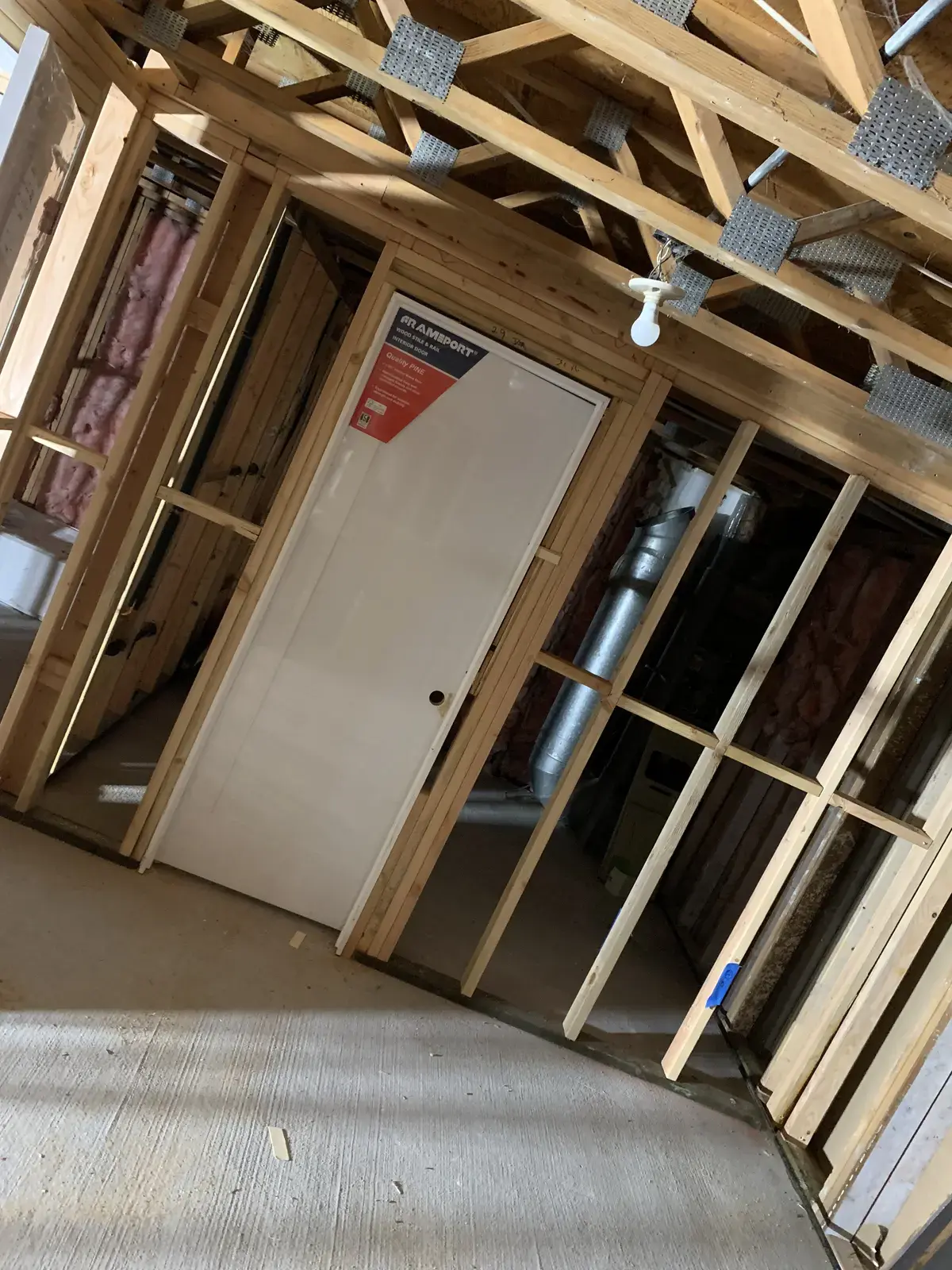 Interior of the ADU framed out with doors set and insulation in the walls