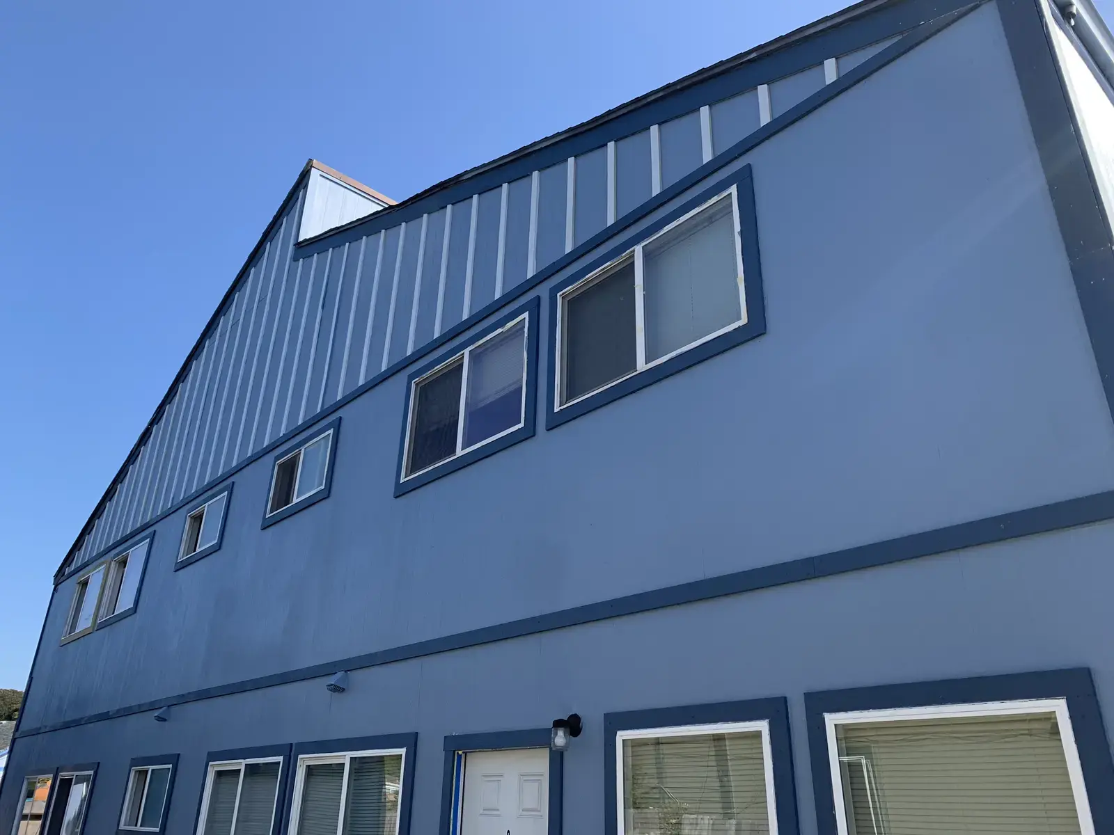 Finished four-unit apartment building in Arcata clad in light blue Hardie panel with board-and-batten trim