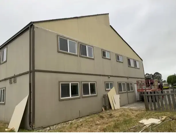 The Arcata apartment building before work began, clad in weathered tan T1-11 wood siding