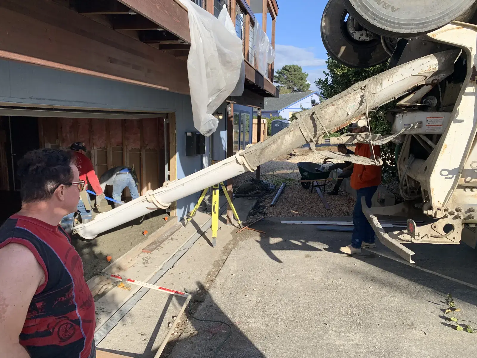 Concrete pump truck placing concrete at the property with the crew working the pour