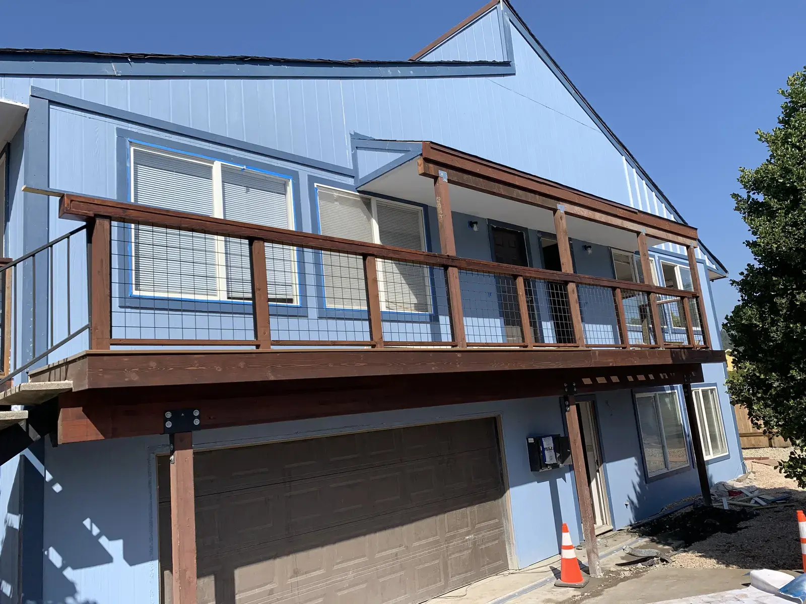 Finished Trex Havana Gold deck above the garage with cedar rails and welded wire infill