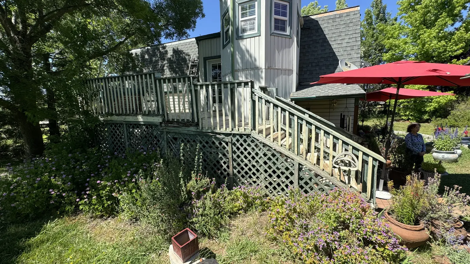 The original weathered gray deck with aging lattice and railing