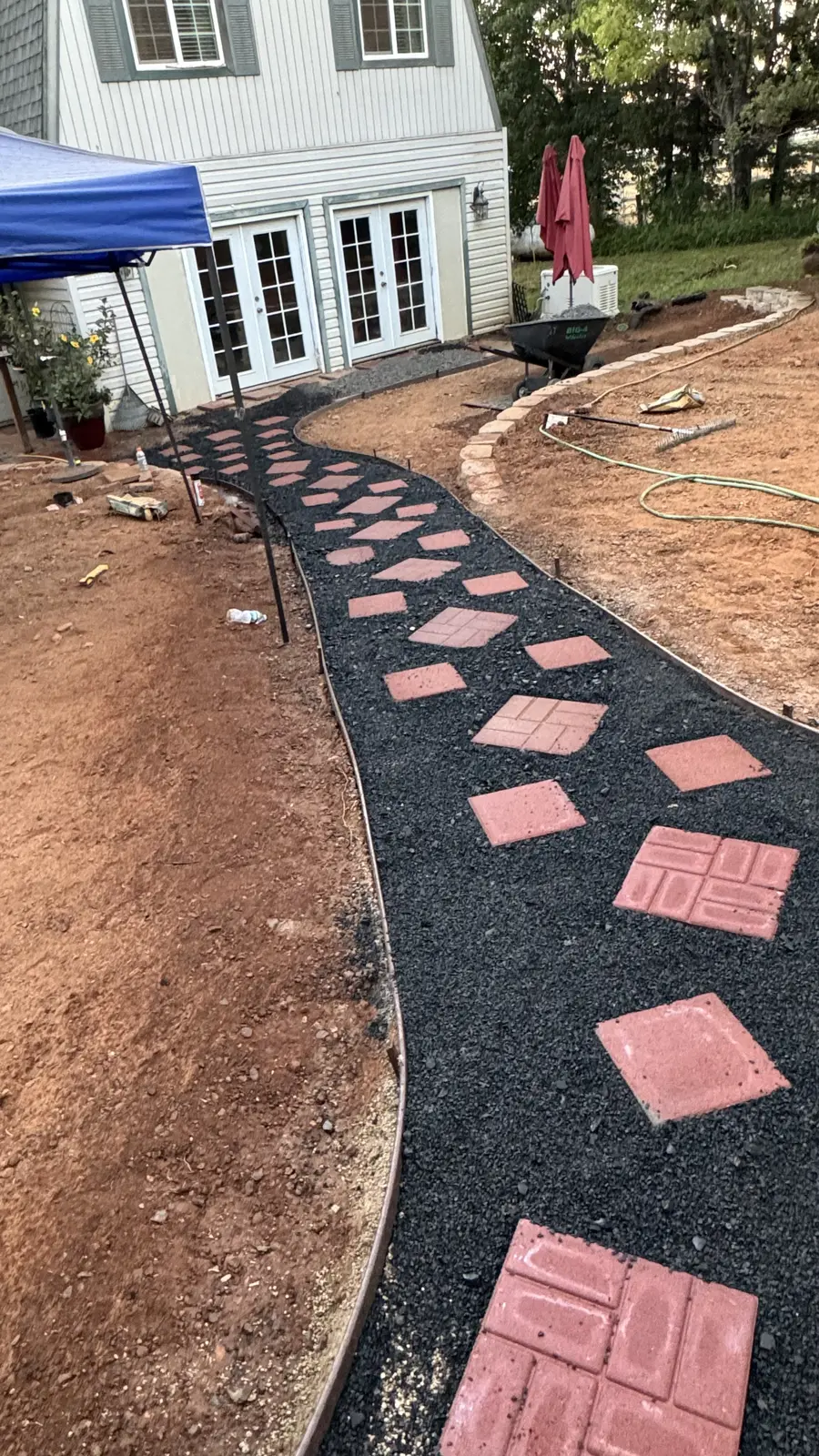 Paver walkway going in over a compacted base with the stone border set