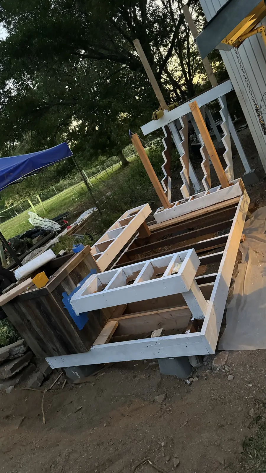 White railing components and balusters staged on site before assembly