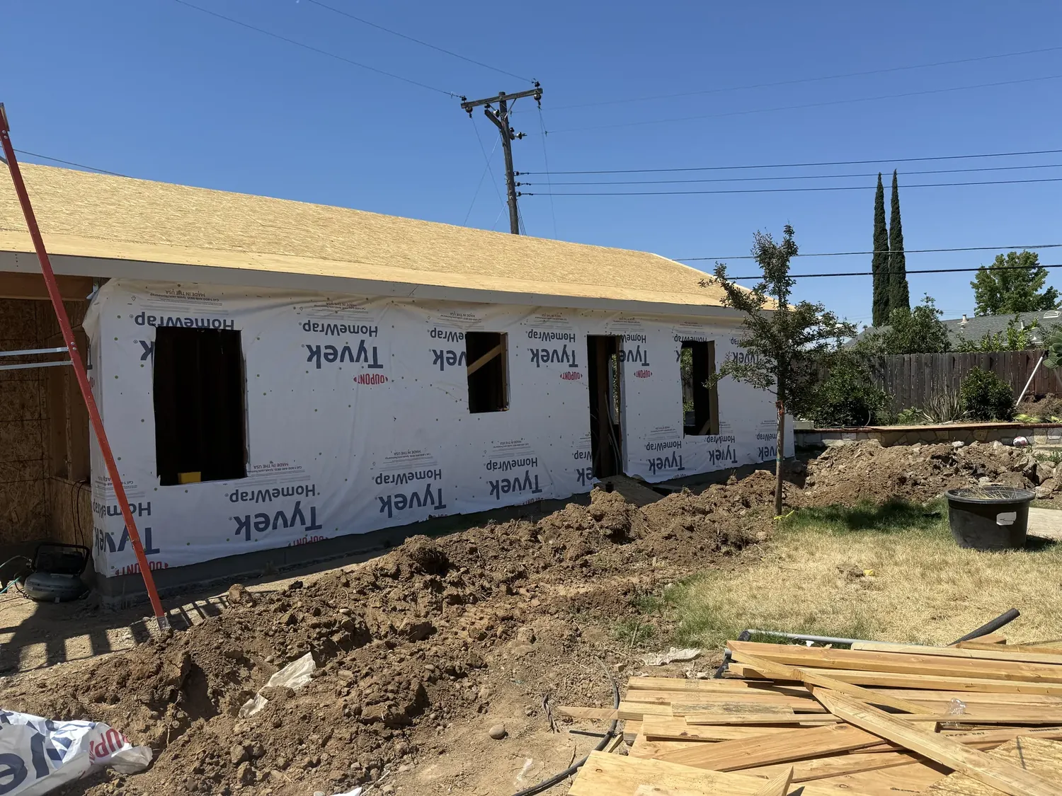 DuPont Tyvek house wrap installed over the ADU sheathing with window openings still open